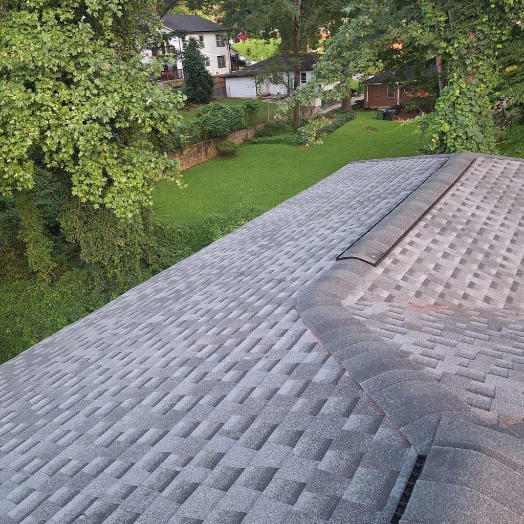 New gray asphalt shingle roof installation on suburban home surrounded by trees and lawn, HD Pro Roofing project.