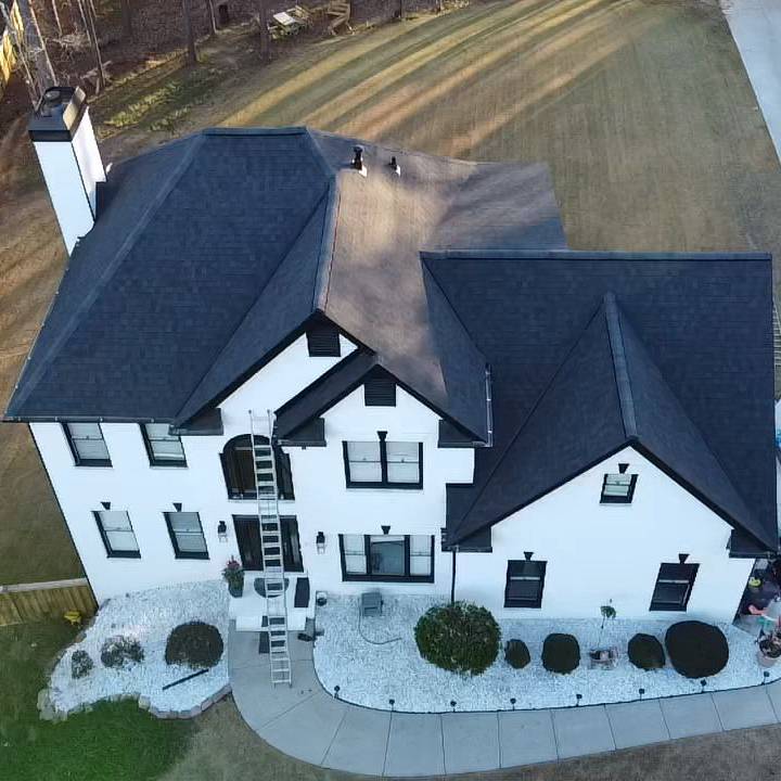 Black asphalt shingle roof on white two-story house, ladder set for roofing inspection, HD Pro Roofing expertise displayed